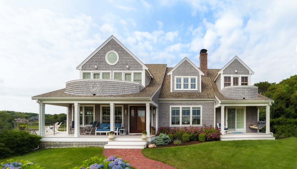 Example of a beach style gray two-story wood exterior home design in Boston with a shingle roof