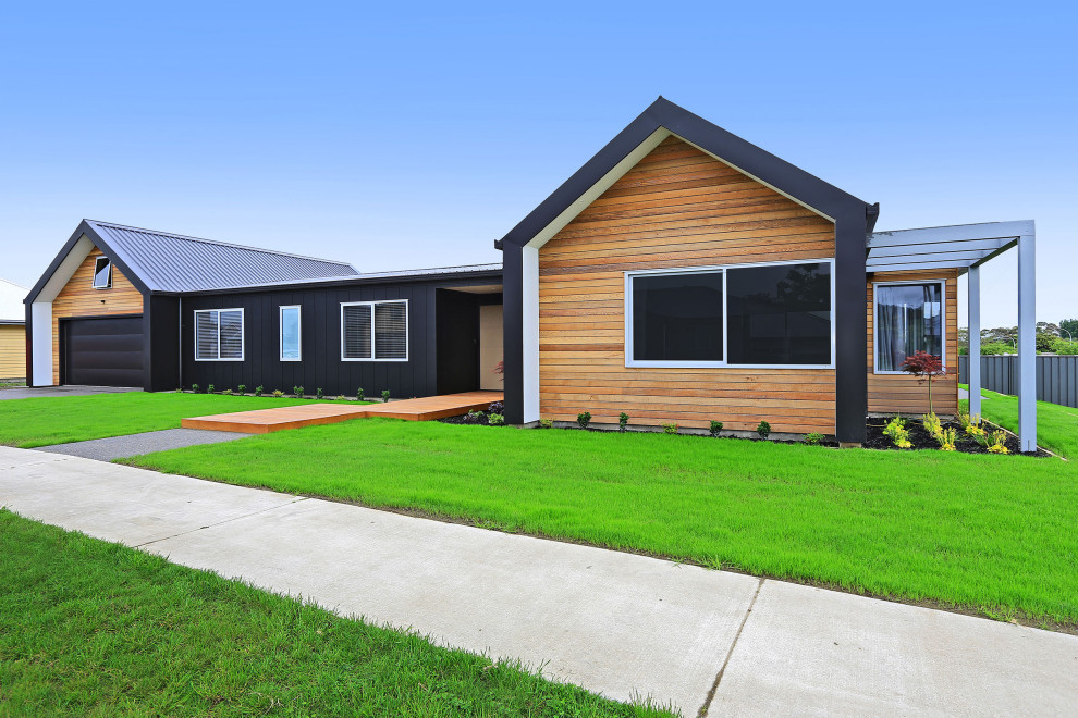 Inspiration for a medium sized and black modern bungalow detached house in Wellington with wood cladding, a pitched roof, a metal roof and a black roof.