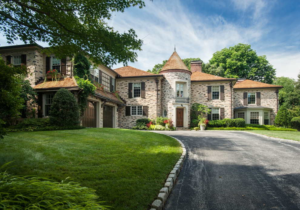 Photo of a large and beige classic house exterior in Philadelphia with three floors, stone cladding and a hip roof.