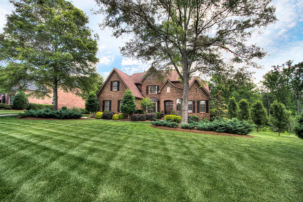 Huge elegant brown two-story exterior home photo in Charlotte