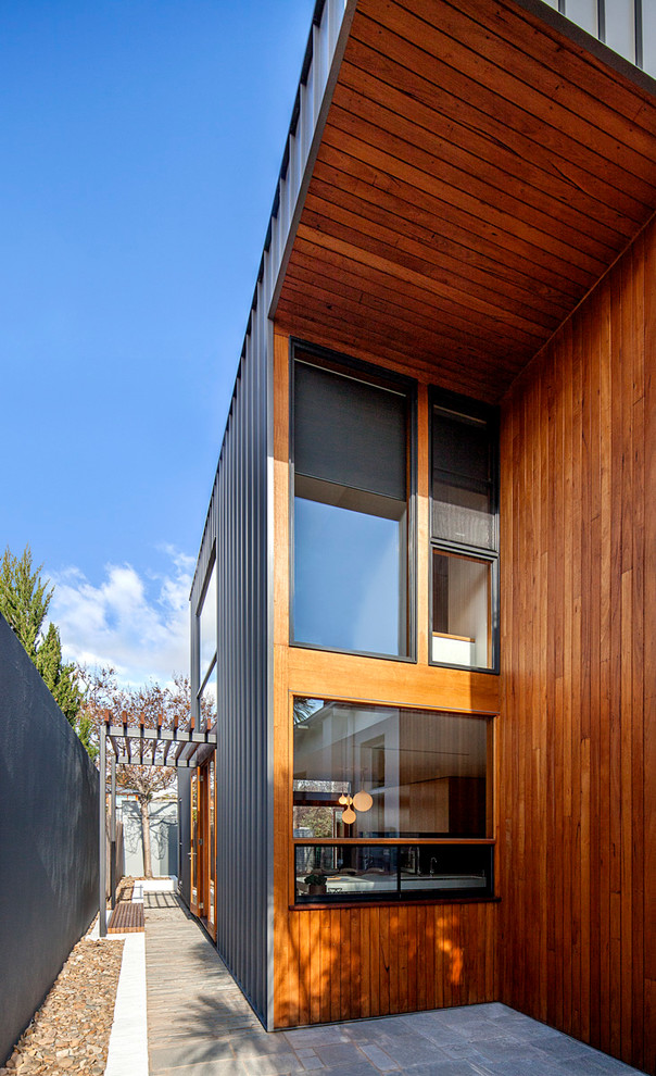 На фото: двухэтажный, серый дом среднего размера в стиле модернизм с облицовкой из металла с
