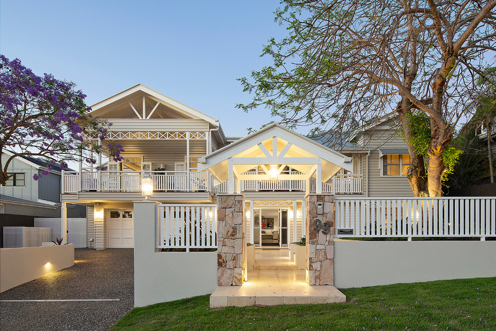 Large and beige nautical two floor detached house in Brisbane with wood cladding and a pitched roof.