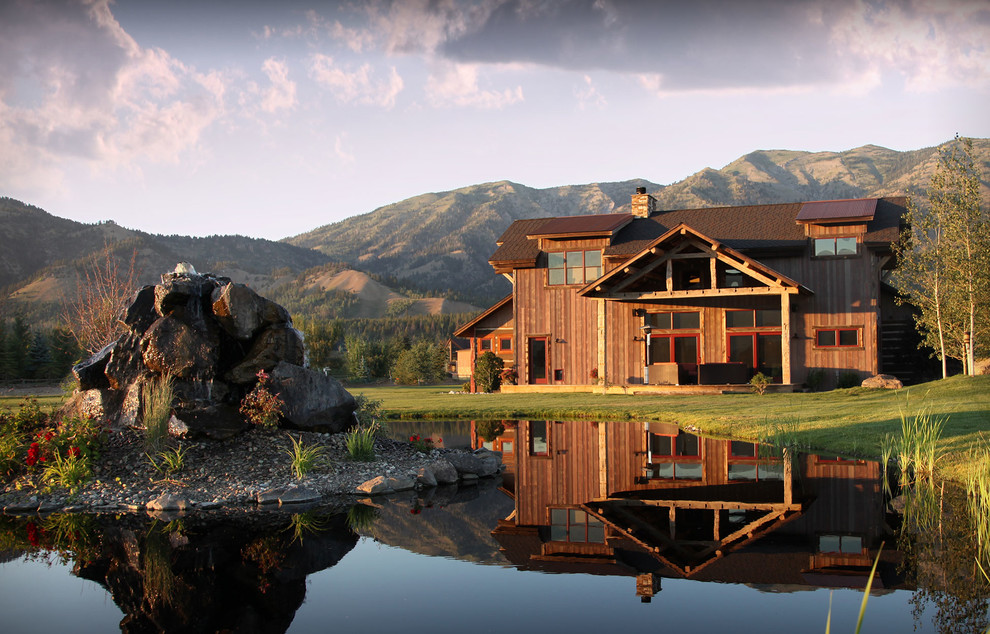 Idee per la villa grande marrone rustica a due piani con rivestimento in legno e tetto a capanna