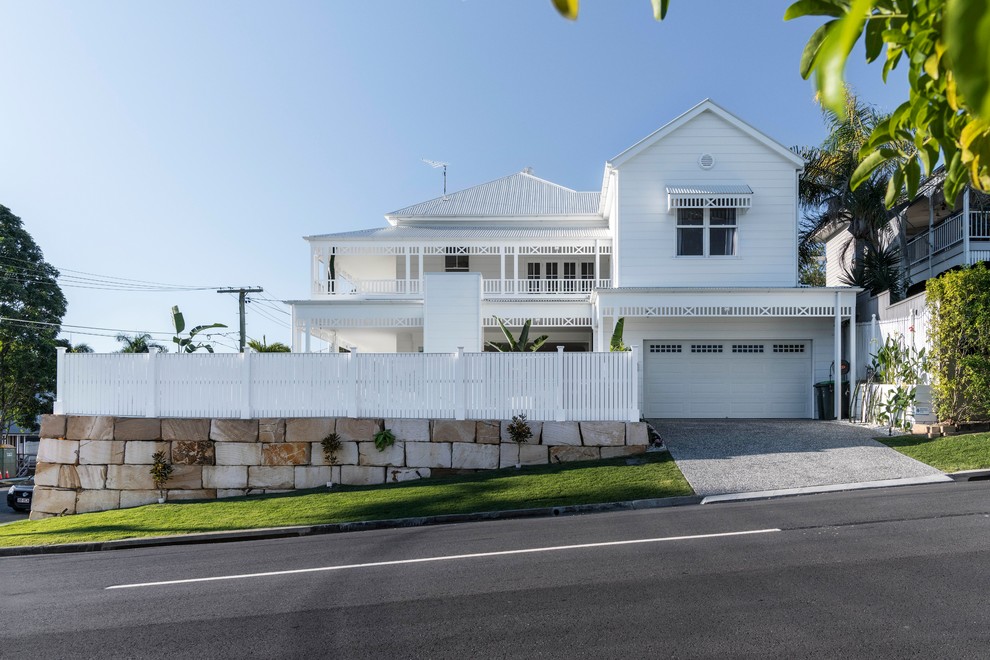 Exemple d'une façade de maison blanche bord de mer à un étage avec un revêtement en vinyle, un toit à quatre pans et un toit en métal.