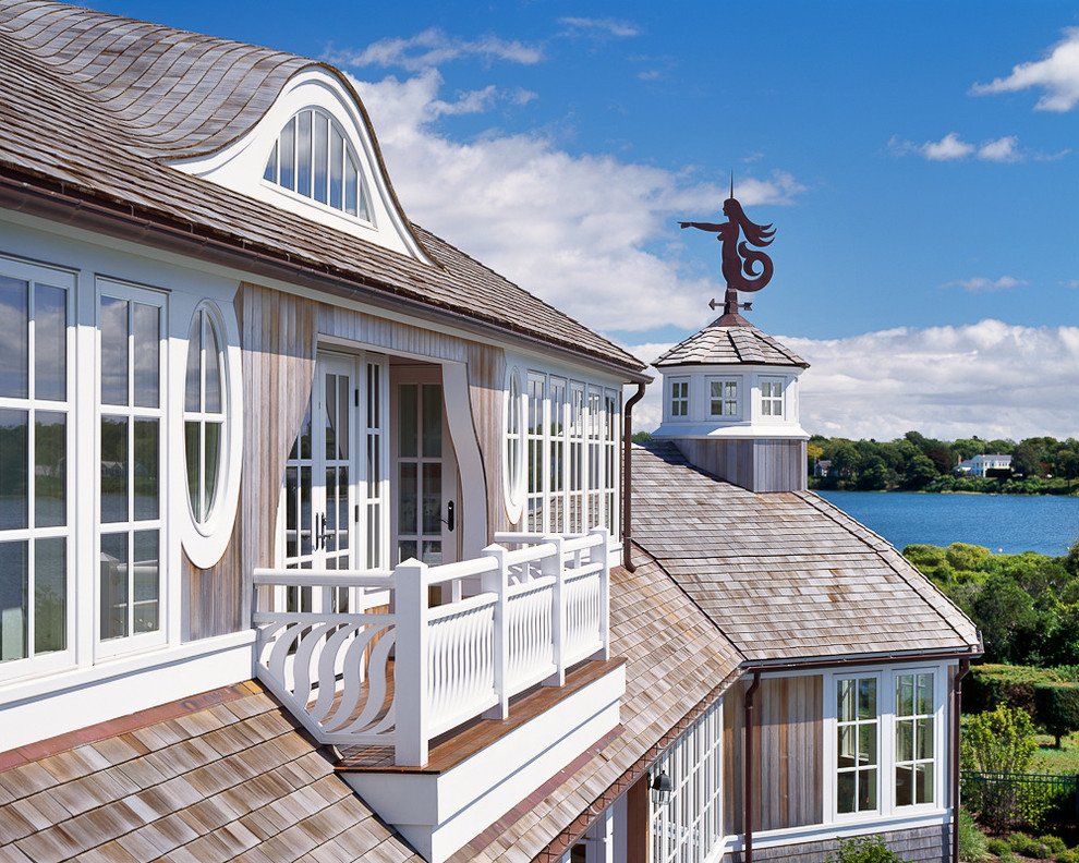 Exemple d'une très grande façade de maison grise bord de mer en bois à un étage avec un toit en shingle.