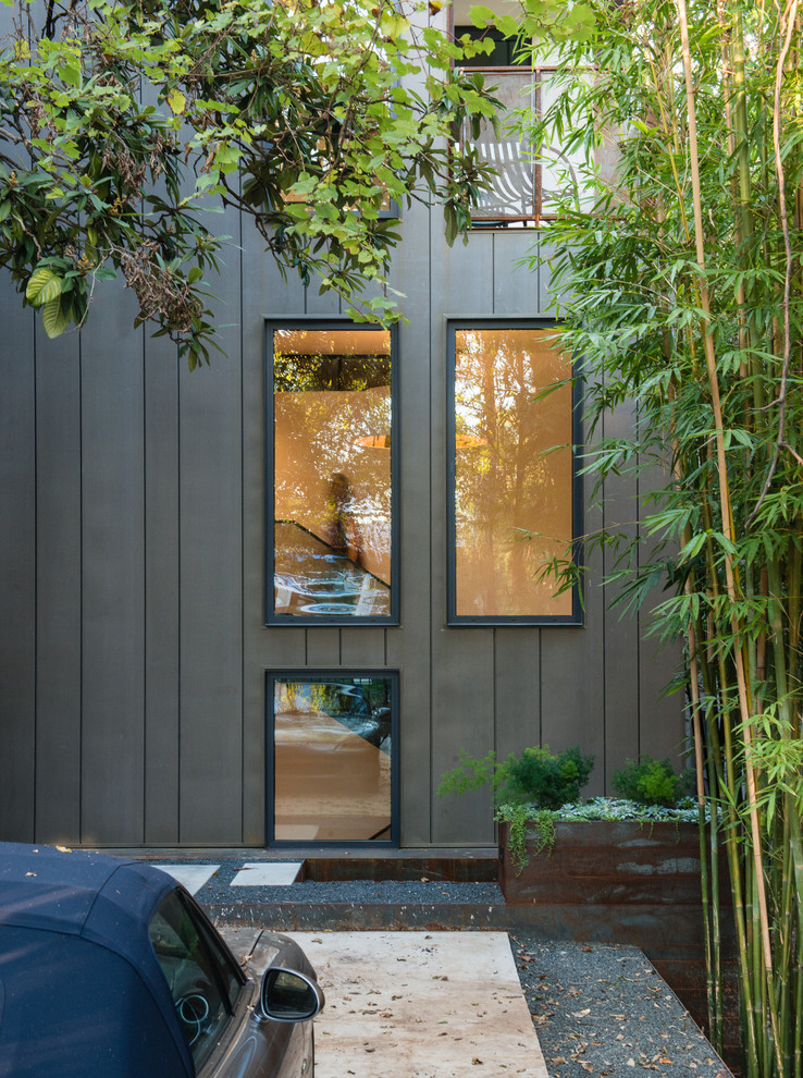 На фото: большой, трехэтажный, коричневый частный загородный дом в современном стиле с облицовкой из металла с