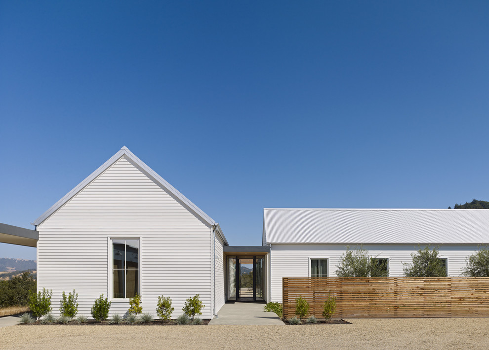 Example of a large farmhouse white one-story wood gable roof design in San Francisco