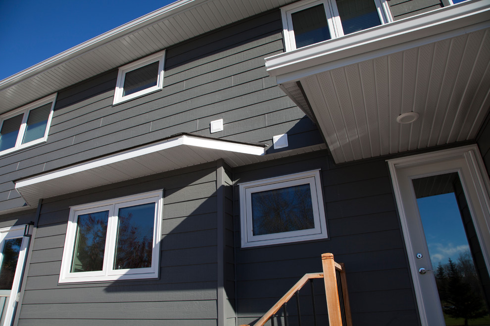 Idée de décoration pour une grande façade de maison bleue tradition en panneau de béton fibré à un étage avec un toit à deux pans.