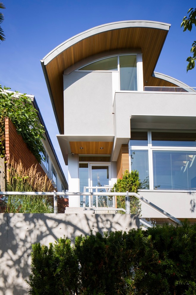На фото: двухэтажный, серый дом среднего размера в современном стиле с комбинированной облицовкой с