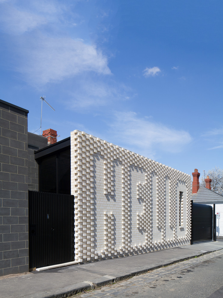 Einstöckiges, Kleines Modernes Haus mit Backsteinfassade, weißer Fassadenfarbe und Flachdach in Melbourne