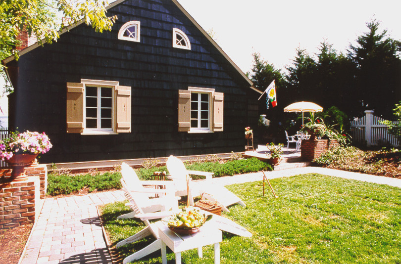 Idée de décoration pour une façade de maison noire tradition en bois de taille moyenne et à un étage avec un toit à deux pans.