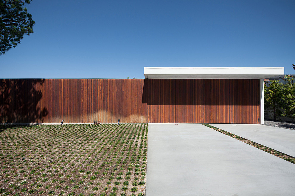 Ejemplo de fachada de casa marrón moderna de tamaño medio de una planta con revestimiento de metal y tejado plano