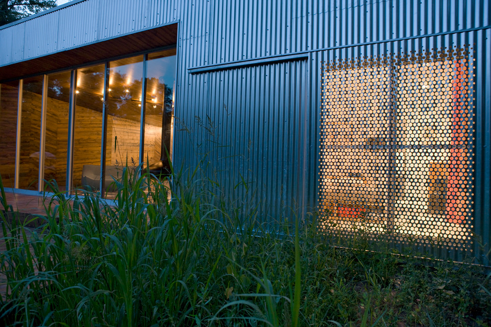 Esempio della facciata di una casa grigia contemporanea a un piano di medie dimensioni con rivestimento in metallo