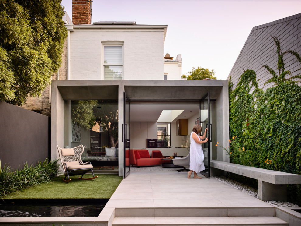 Zweistöckiges Modernes Einfamilienhaus mit Betonfassade, weißer Fassadenfarbe und Flachdach in Melbourne