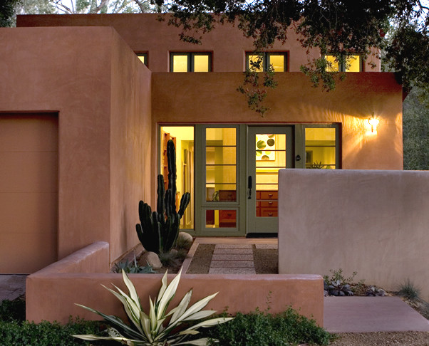 Cette image montre une façade de maison marron minimaliste en stuc à un étage et de taille moyenne avec un toit plat.