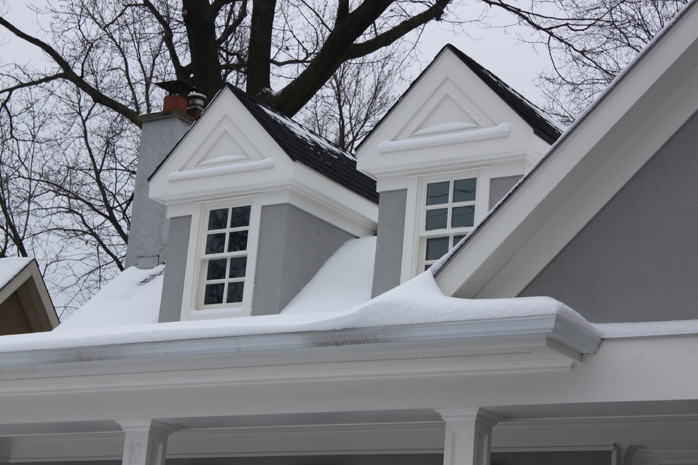 Exemple d'une façade de maison grise chic en stuc de taille moyenne et à un étage avec un toit à deux pans.