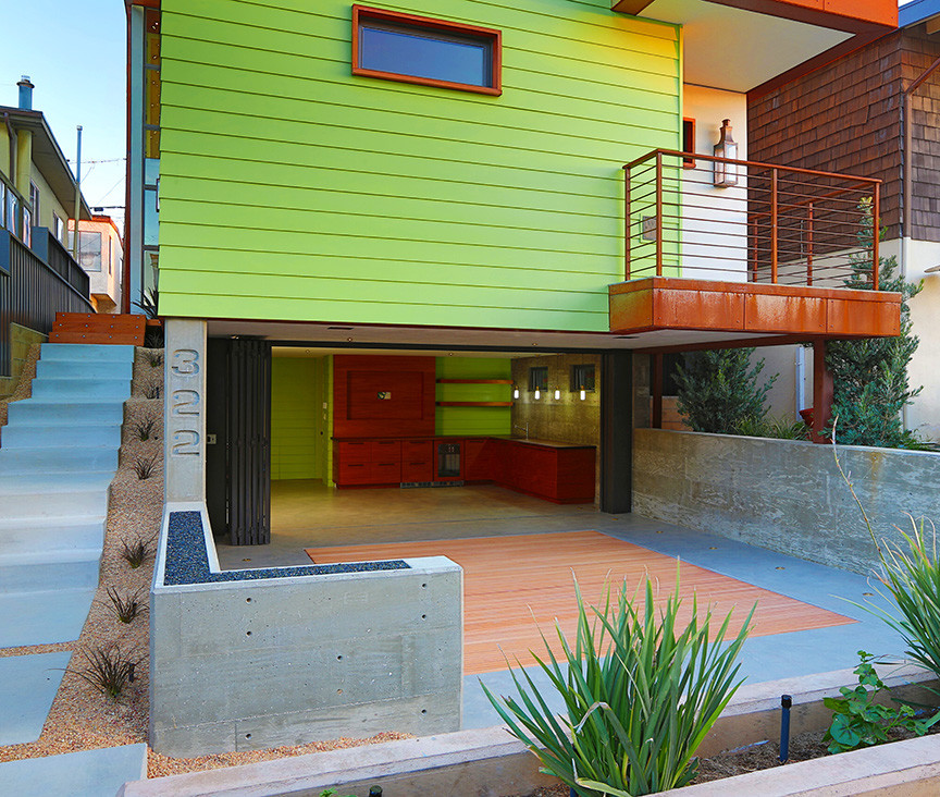 Large trendy green three-story wood exterior home photo in Los Angeles