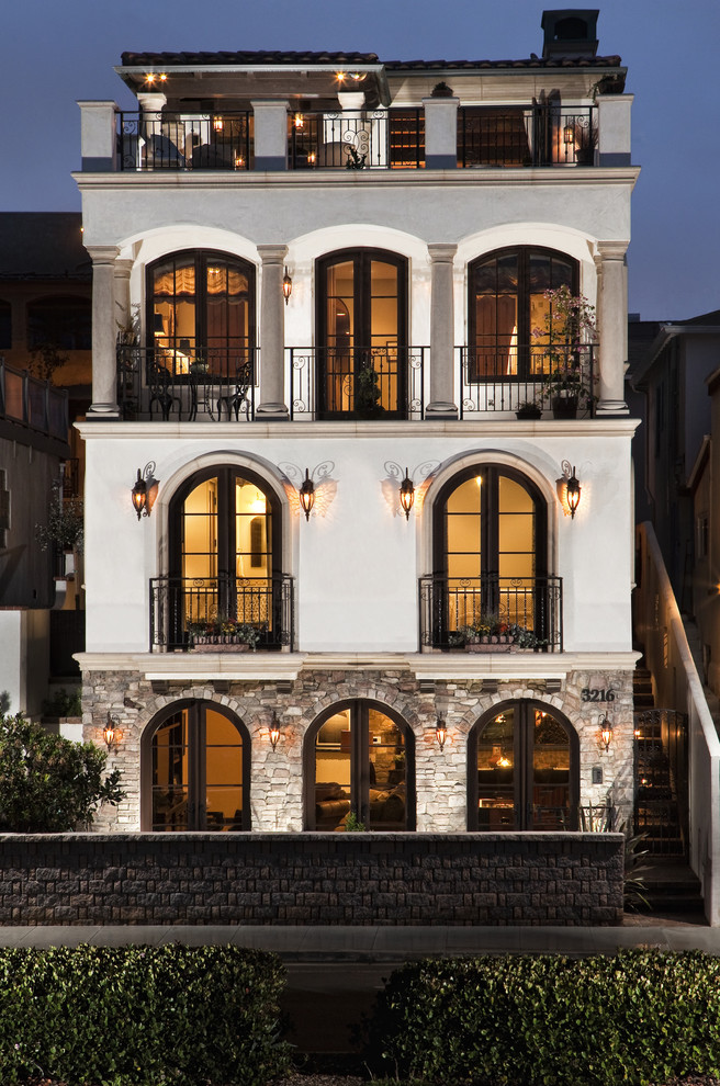Immagine della facciata di una casa grande beige mediterranea a quattro piani con rivestimenti misti