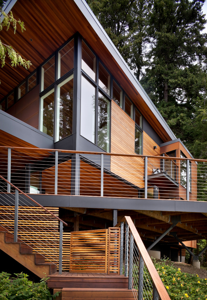 Inspiration pour une petite façade de maison métallique et marron design à un étage avec un toit en appentis et un toit en métal.