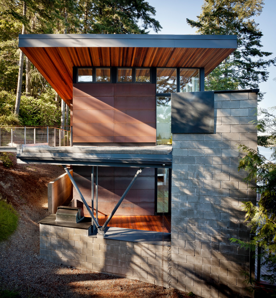 Kleines, Zweistöckiges Modernes Einfamilienhaus mit Metallfassade, roter Fassadenfarbe, Pultdach und Blechdach in Seattle