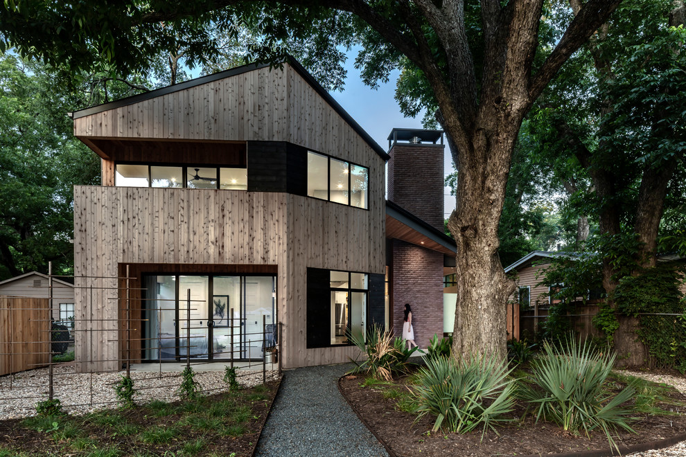 Mid-sized minimalist brown two-story wood exterior home photo in Austin with a metal roof