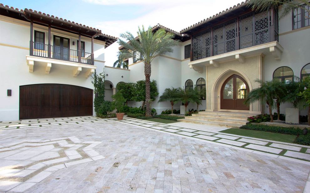 Design ideas for a mediterranean two floor house exterior in Miami with wood cladding.