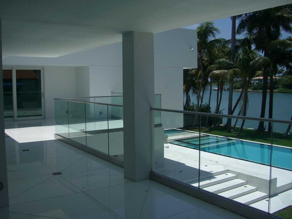 Large minimalist white two-story flat roof photo in Miami