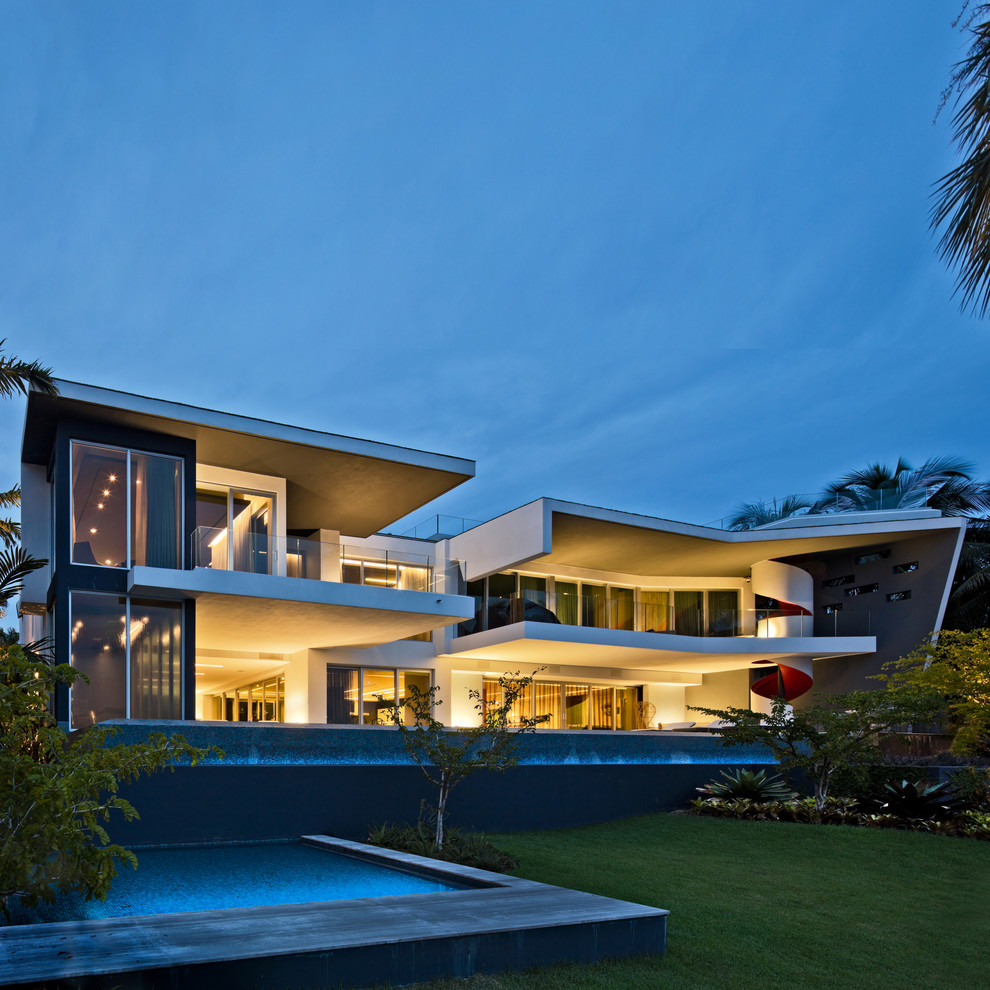 На фото: двухэтажный, большой, серый частный загородный дом в стиле модернизм с плоской крышей и облицовкой из цементной штукатурки