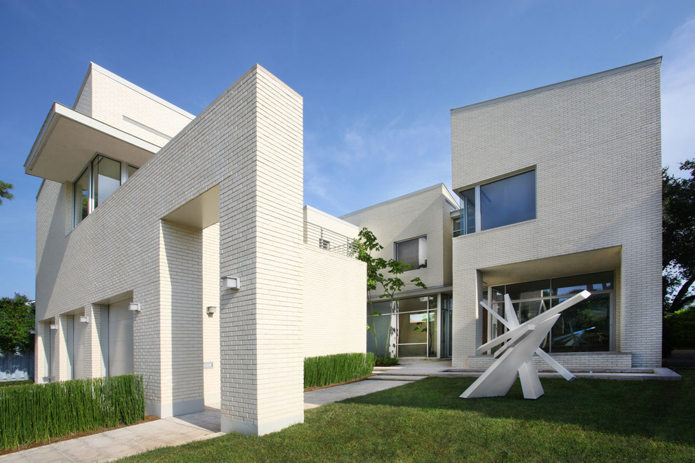 Example of a minimalist white two-story brick exterior home design in New Orleans