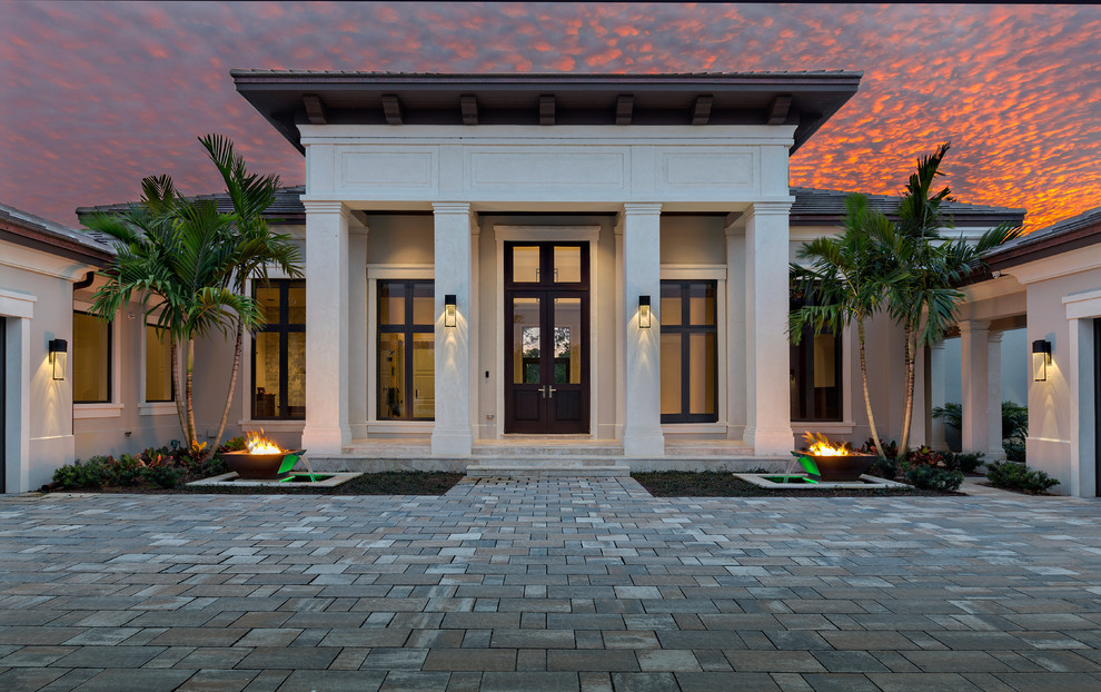 Стильный дизайн: большой, одноэтажный, серый дом в современном стиле с облицовкой из цементной штукатурки и вальмовой крышей - последний тренд