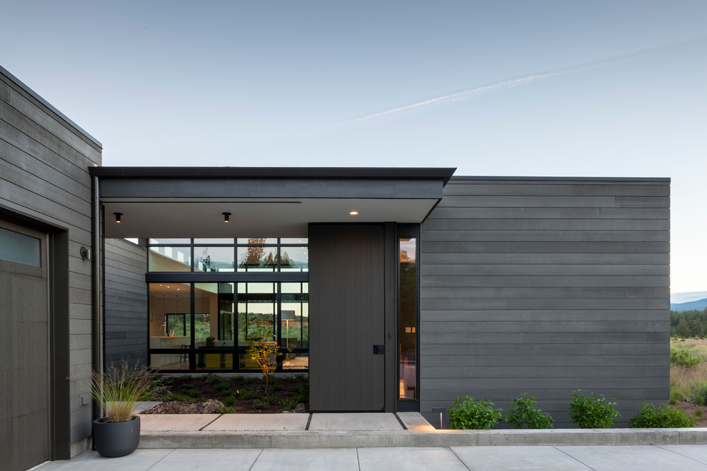 Inspiration pour une façade de maison minimaliste en bois de taille moyenne et de plain-pied avec un toit plat.