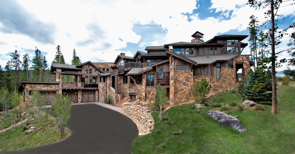 This is an example of a large contemporary house exterior in Denver with stone cladding and three floors.