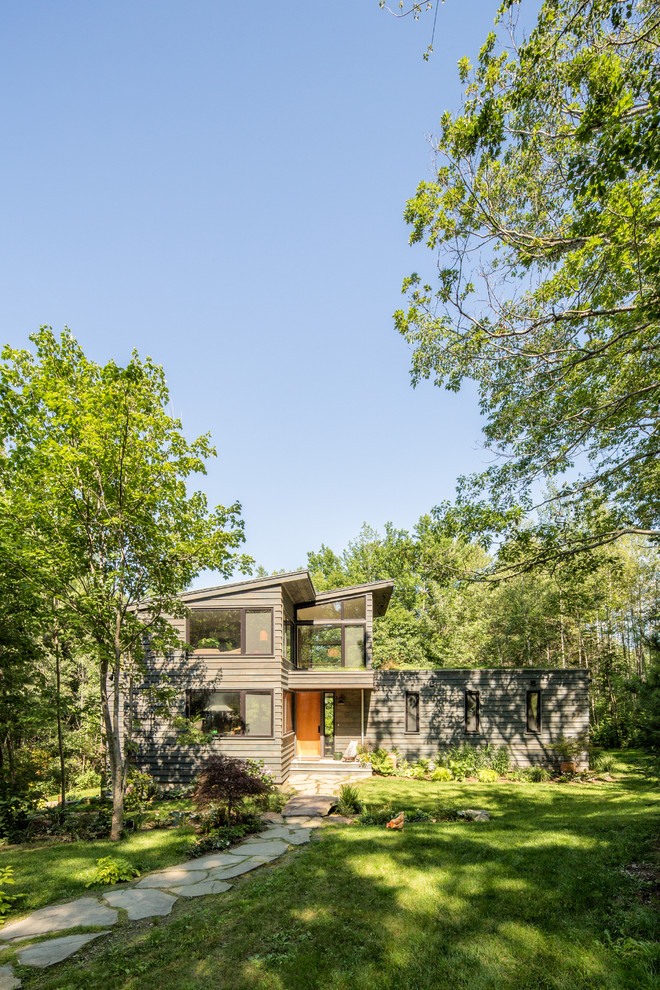 Пример оригинального дизайна: маленький, двухэтажный, деревянный, серый многоквартирный дом в стиле рустика с односкатной крышей и металлической крышей для на участке и в саду