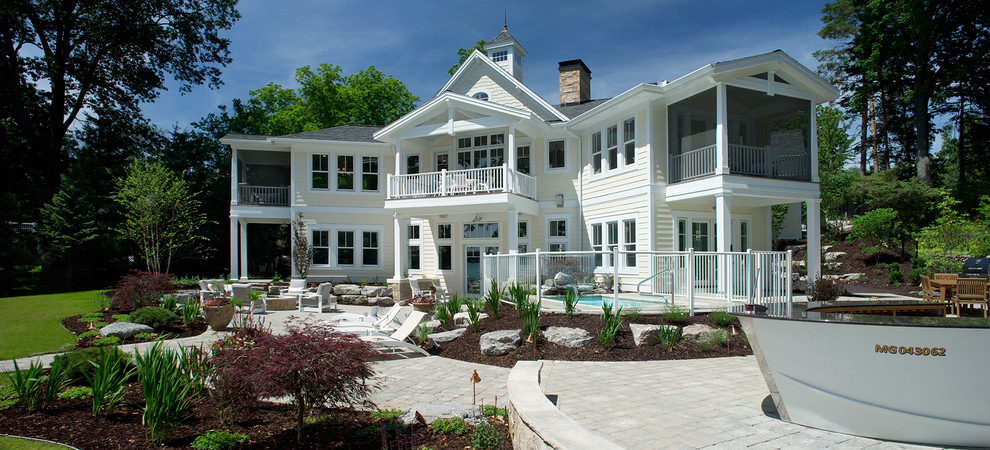 Immagine della facciata di una casa grande bianca classica a tre piani con rivestimento con lastre in cemento
