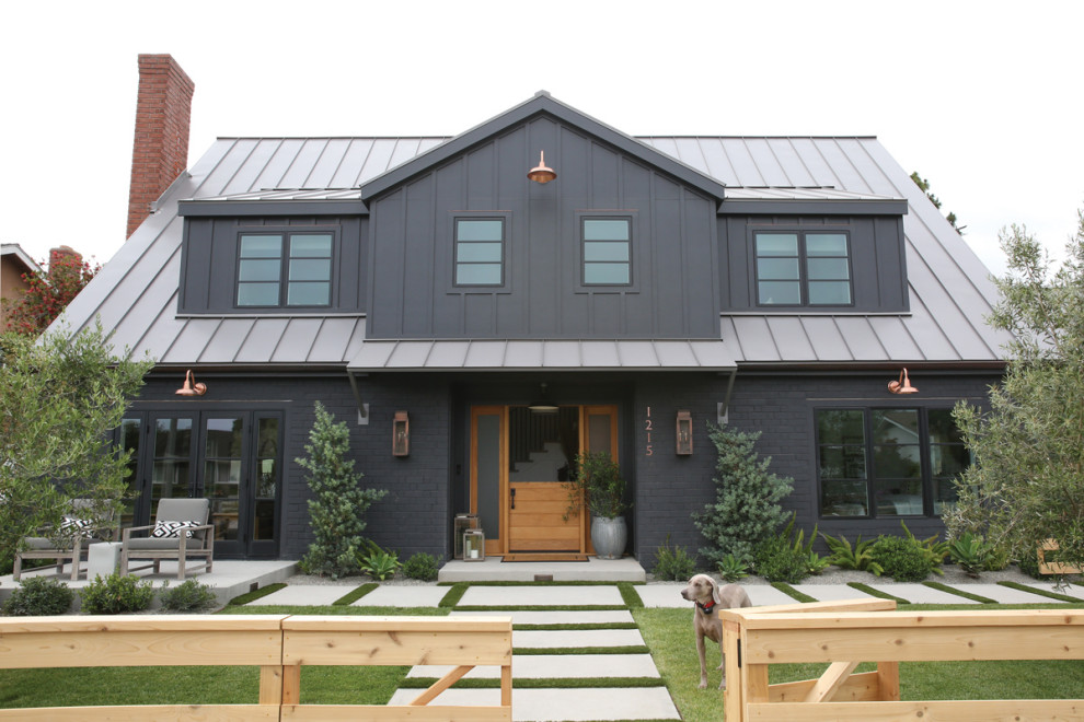 Design ideas for a black rural two floor brick detached house in Orange County with a pitched roof and a metal roof.