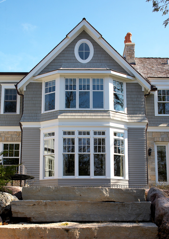 Imagen de fachada de casa gris tradicional extra grande de dos plantas con revestimientos combinados, tejado a dos aguas y tejado de teja de madera