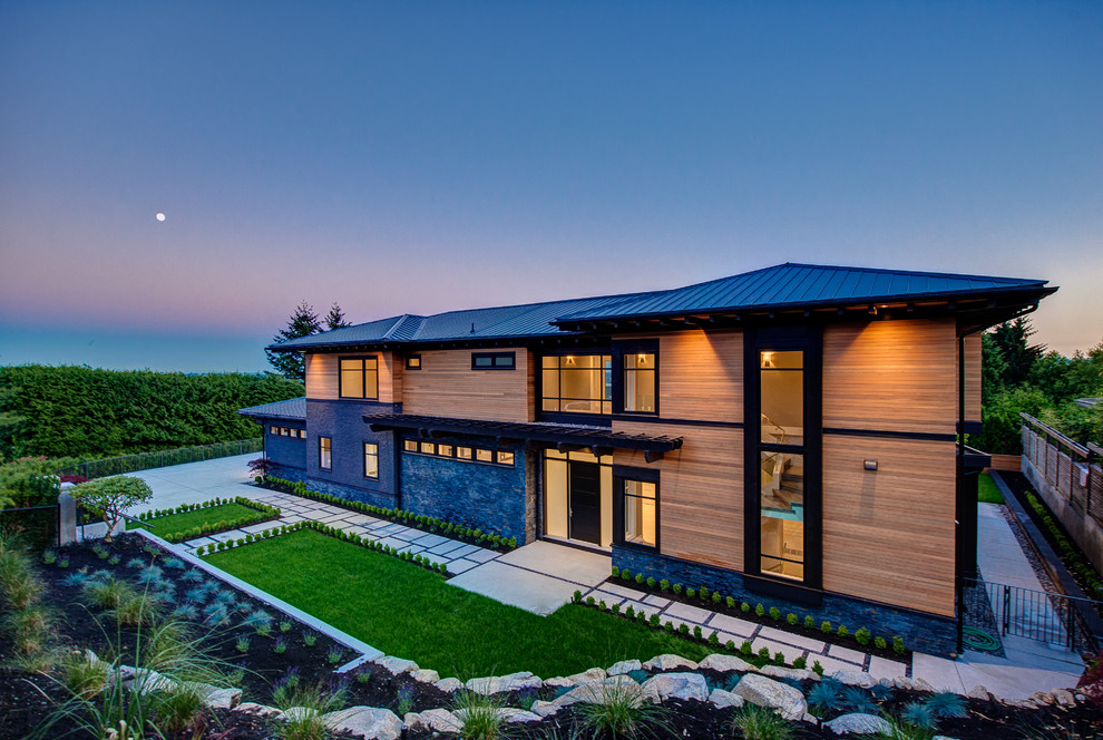 Photo of a large contemporary two floor house exterior in Vancouver with mixed cladding and a hip roof.