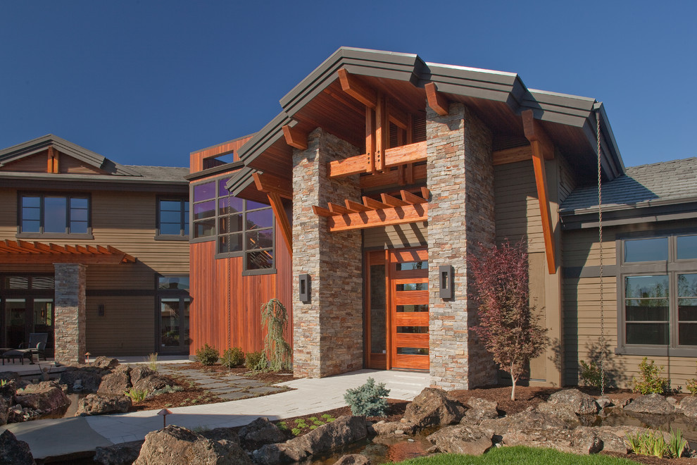 Idée de décoration pour une grande façade de maison multicolore chalet en pierre à un étage avec un toit à deux pans et un toit en shingle.