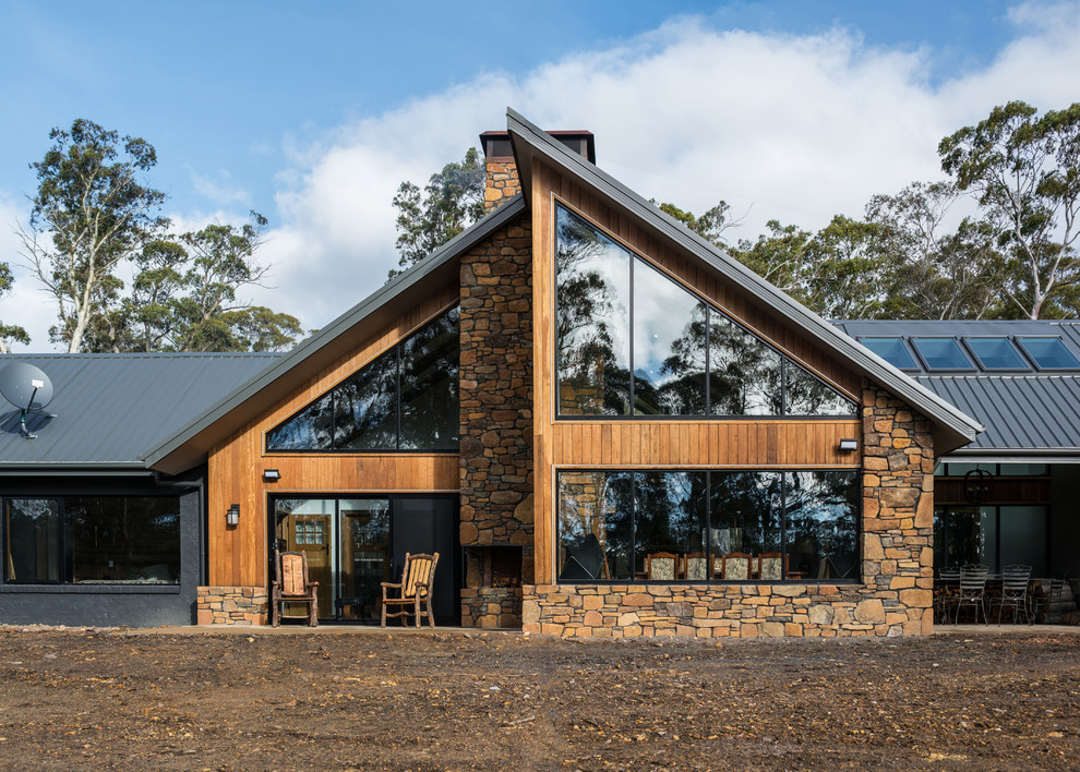 Réalisation d'une façade de maison marron design de plain-pied avec un revêtement mixte, un toit en appentis et un toit en métal.