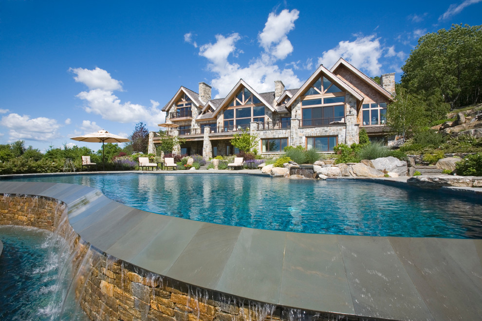 Huge mountain style gray two-story stone exterior home photo in New York