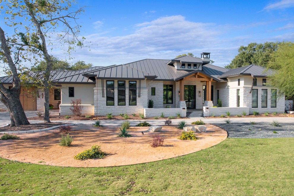 This is an example of a white contemporary bungalow detached house in Austin with stone cladding, a hip roof and a metal roof.