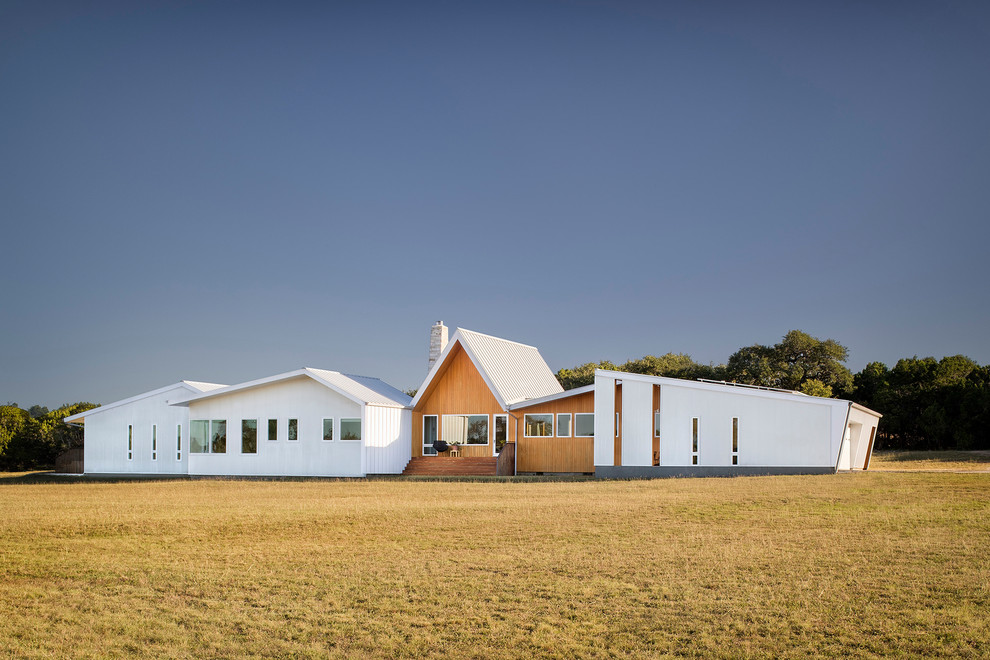 Esempio della villa bianca contemporanea a un piano di medie dimensioni con tetto a capanna, copertura in metallo o lamiera e rivestimenti misti
