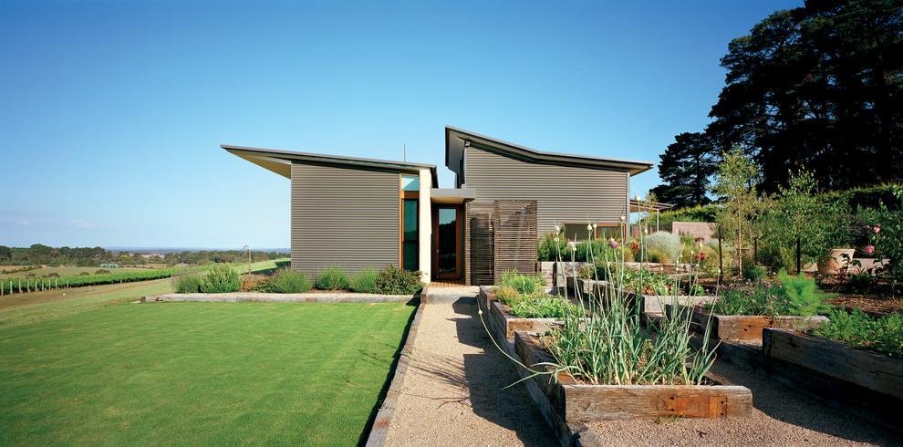 This is an example of a large and gey contemporary split-level house exterior in Melbourne with metal cladding.