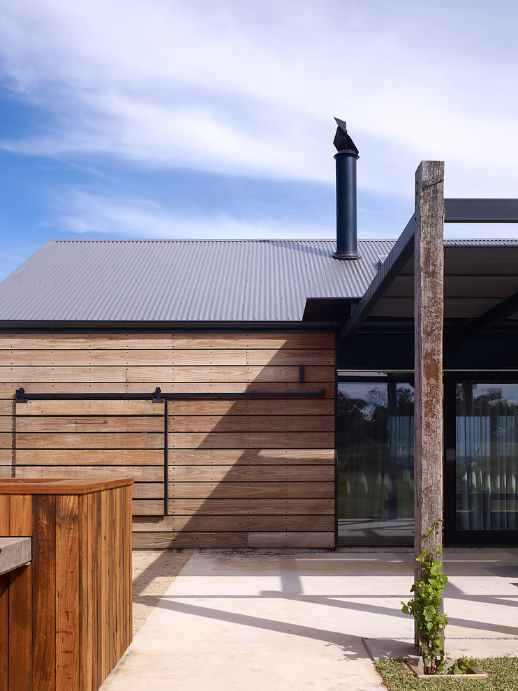 Esempio della casa con tetto a falda unica nero country a un piano di medie dimensioni con rivestimento in legno