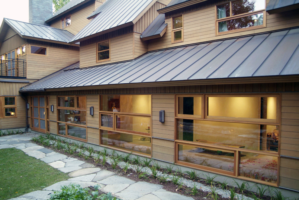 Foto della villa grande beige rustica a due piani con rivestimento in legno e copertura in metallo o lamiera
