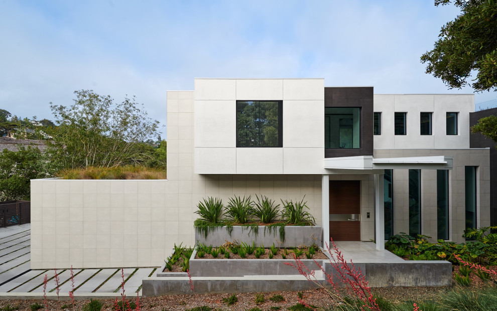 Imagen de fachada de casa multicolor actual de dos plantas con revestimientos combinados y tejado plano