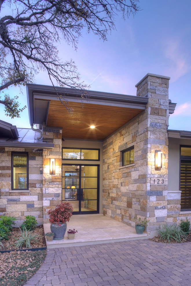 Large trendy beige one-story mixed siding exterior home photo in Austin with a shed roof