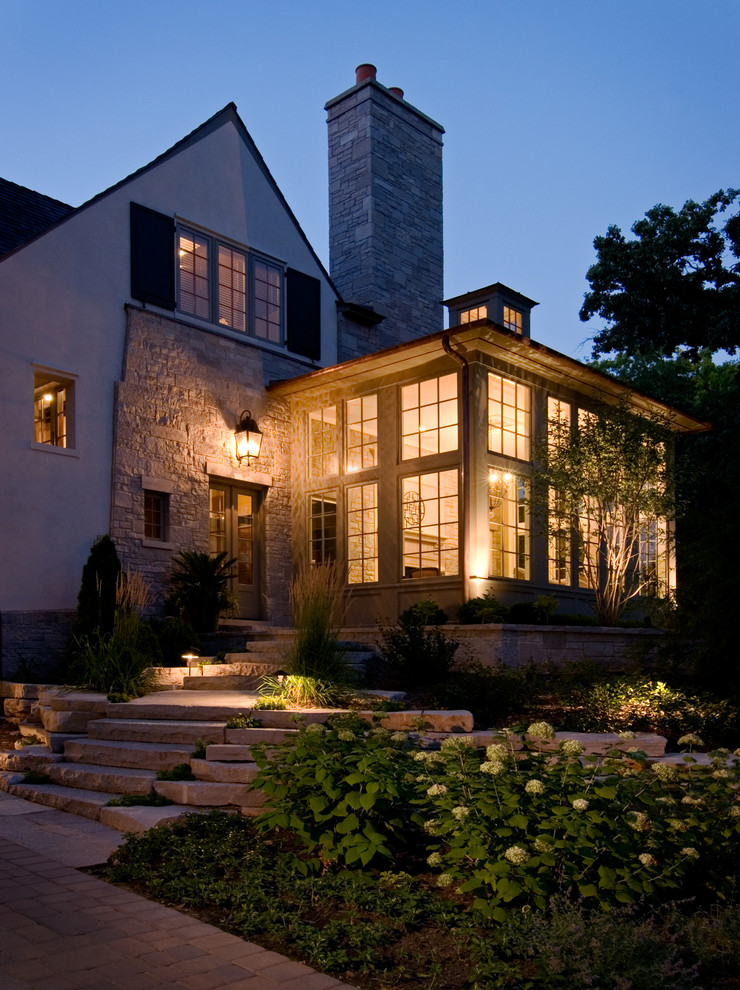 Пример оригинального дизайна: двухэтажный, бежевый дом в стиле фьюжн с облицовкой из камня