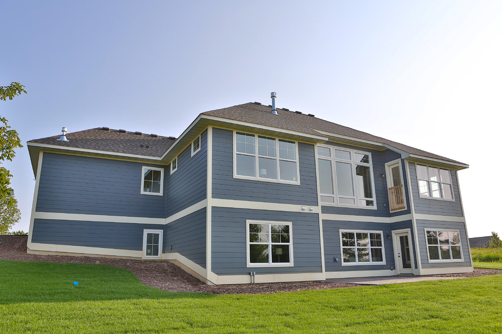 Пример оригинального дизайна: одноэтажный, синий дом среднего размера с облицовкой из винила