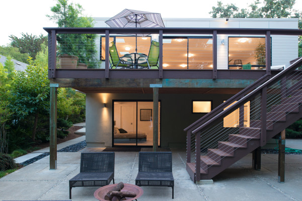 Modelo de fachada de casa beige actual de tamaño medio de dos plantas con tejado plano y revestimientos combinados